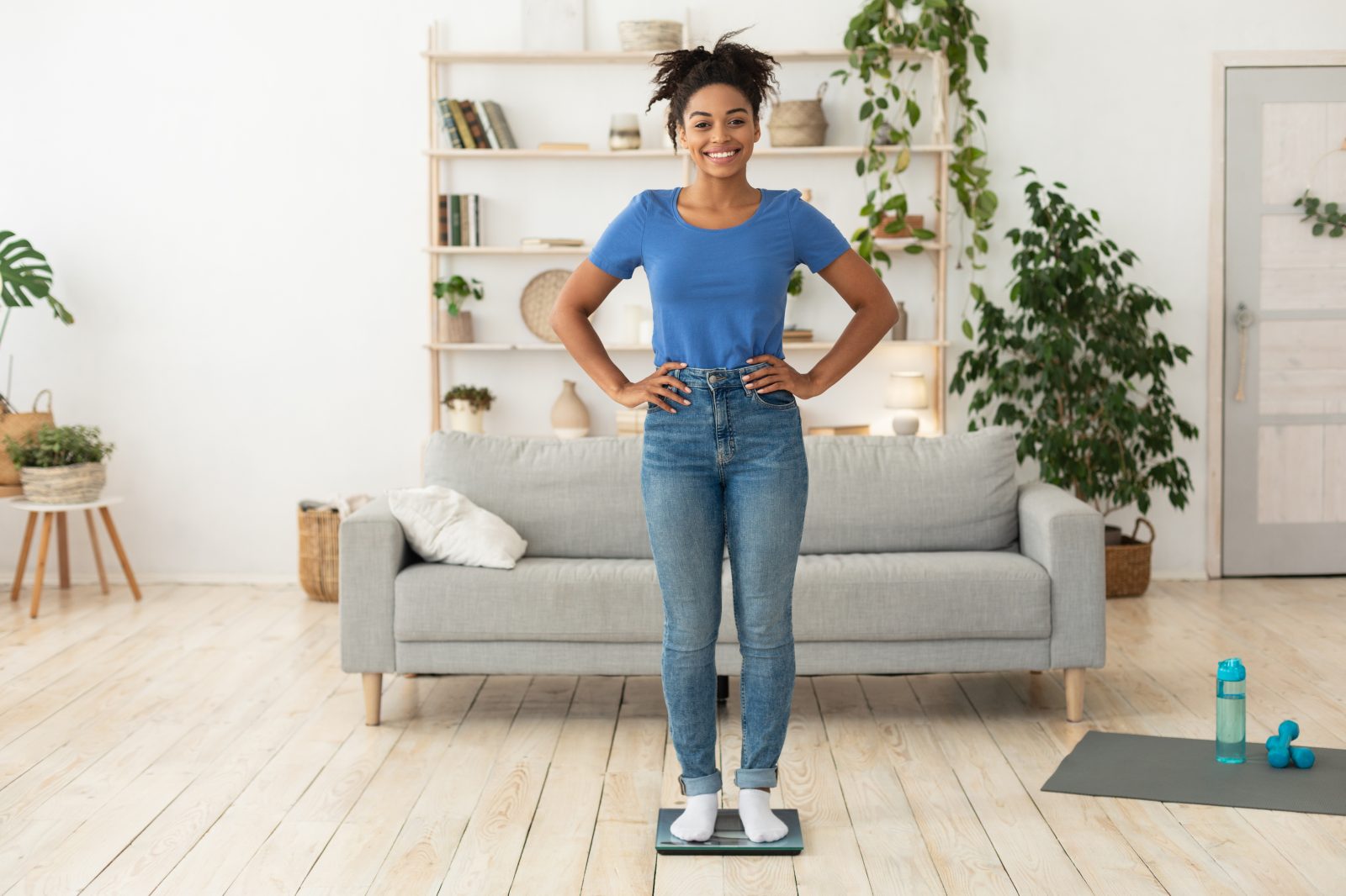 Glad kvinna på personvåg efter framgångsrik viktminskning
